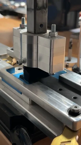 Cutting the tip of a black leather strap on a press in the Variani atelier