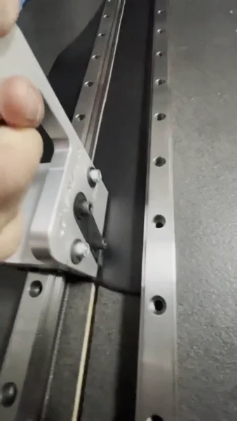 A leather strap being guided along a metal rail in the Variani atelier