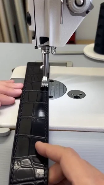 Stitching an alligator-pattern leather belt in the Variani atelier